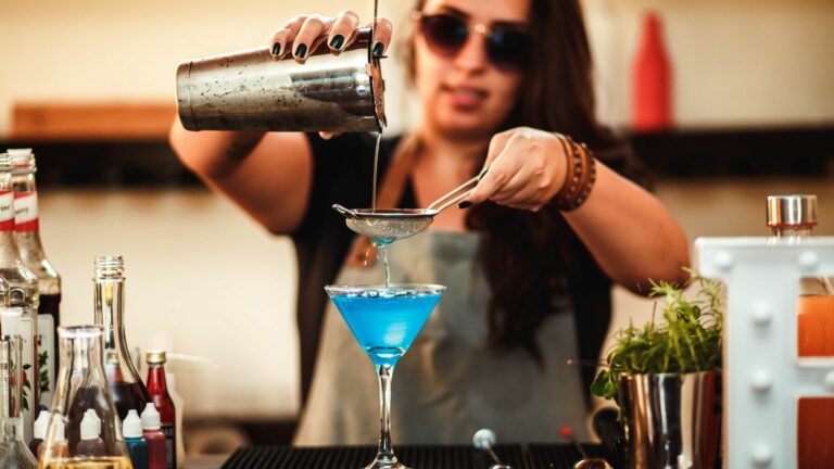 Participant mixing a blue cocktail at a cocktail-making event