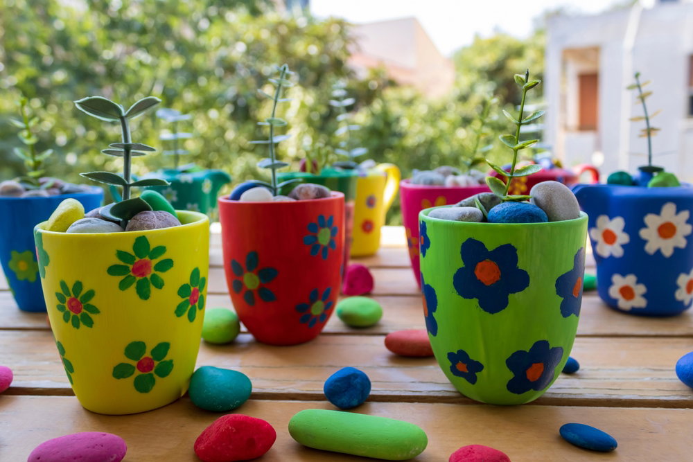 Small,Colorful,Painted,Flower,Pots,On,Garden,Table