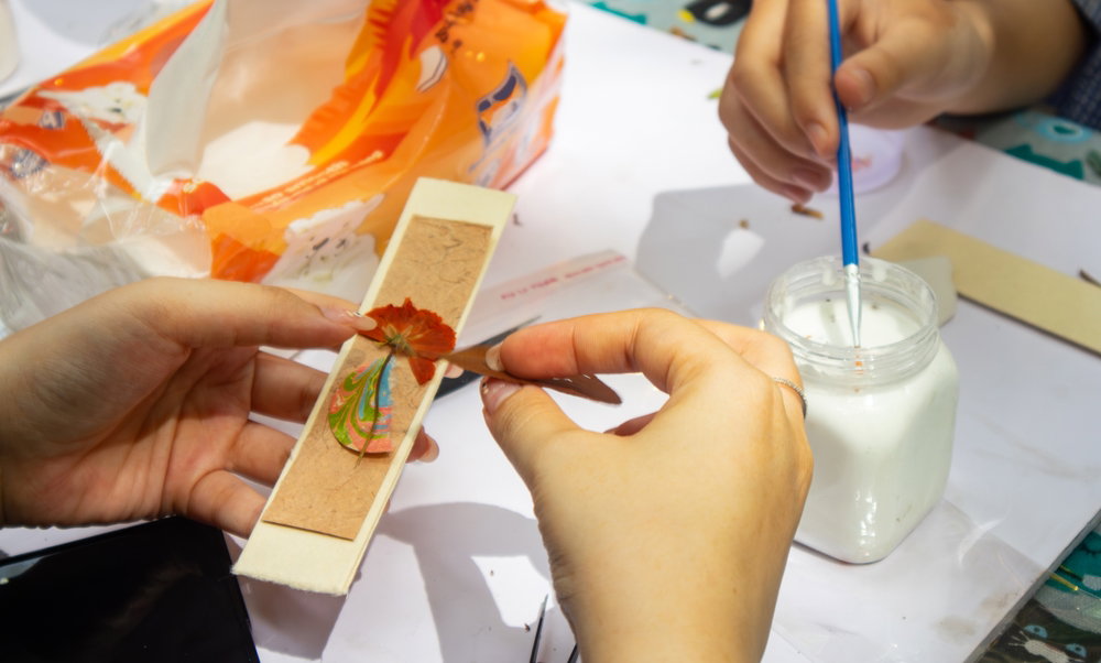 Skilled,Hands,Create,A,Beautiful,Bookmark,Using,Dried,Flowers,,Blending